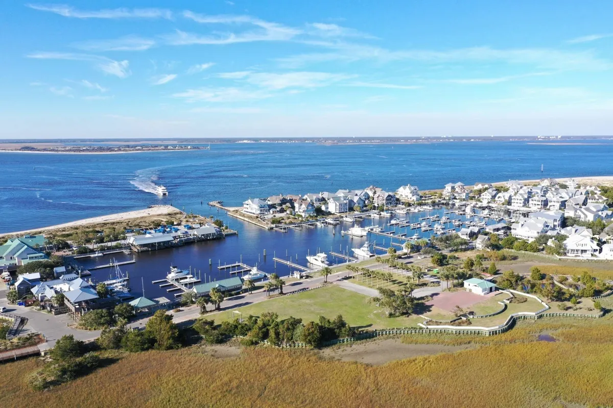 A vibrant marina scene with boats docked along a waterway, bordered by residential homes and a sprawling green park area. The setting feels both exclusive and communal, ideal for boating, fishing, and socializing by the water. The relaxed mood and sunset lighting add to the sense of upscale leisure.